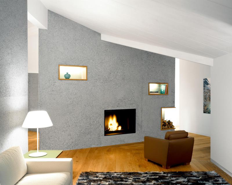Holiday Home Celerina living room with wall element made of bush-hammered concrete and inbuilt fireplace by Rueegg