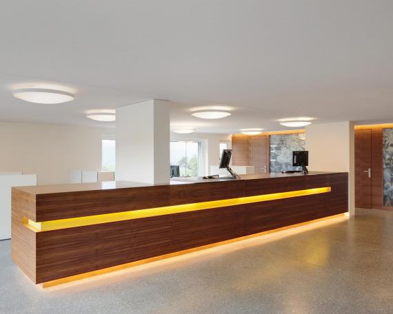 Raiffeisenbank Gommiswald bank counter in walnut with lighting channel