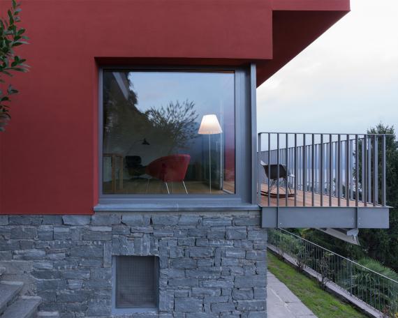 Umbau Ferienhaus Casa Sogno mio Locarno in oxidrot KEIM Farbe gestrichen auf Steinsockel mit Panoramafenster und Balkon 