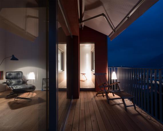 Umbau Ferienhaus Casa Sogno mio Locarno Blick vom Balkon durch die Hebeschiebetüren ins Wohnzimmer bei Nacht