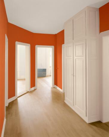 Wohnung Zürich orangefarbener Gang und beige gestrichenes Holzwerk 