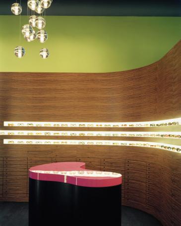 Müller Optik optician store detail eyewear display wall and counter in smoked oak with top in pink 