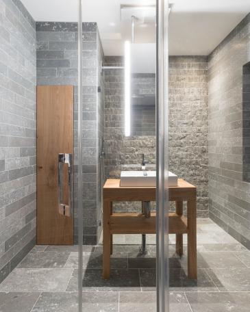 Conversion of holiday home Casa Sogno Mio, Locarno View from steam bath in San Bernardino natural stone towards the shower and washbasin in oak