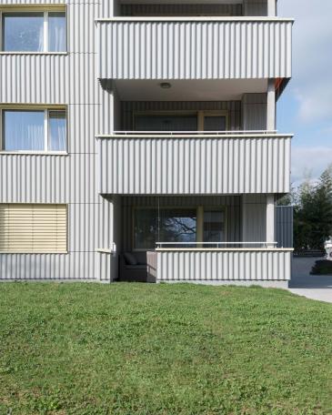 Umbau Mehrfamilienhäuser im Baumgarten in Tann Balkone mit horizontalen Welleternitbänder in Ondapress 36 und offenen Fugen Detail