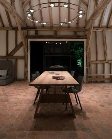 Conversion of barn at Chapel House Farm, Oakwood Hill, Surrey Long Fayland oak table from E15 on hexagonal terracotta tiles aligned with the Sky-Frame window 