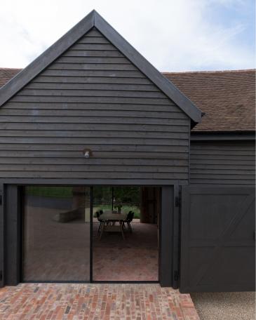 Conversion of barn at Chapel House Farm, Oakwood Hill, Surrey Barn with open doors and Sky-Frame sliding doors 