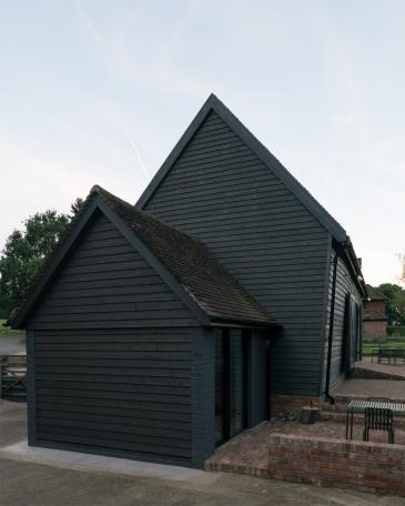 Conversion of barn at Chapel House Farm, Oakwood Hill, Surrey Annex with bathroom and kitchen, facing a brick-paved forecourt 