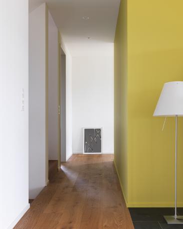 House Wangen_7_Hallway with kitchen at the core in Pale Lime by Little Greene and oak parquet