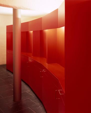 Dudli Optik optician store eyewear display wall from behind in segments in a red matt lacquer 