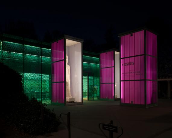 Osiris exhibition Museum Rietberg Three enclosures in hot-dip galvanised steel and polycarbonate panels in violet, colossal statue of the king, shining like lanterns at night