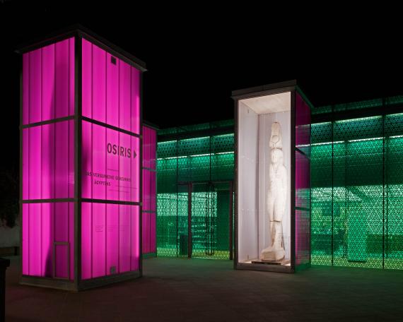 Osiris exhibition Museum Rietberg Three enclosures in hot-dip galvanised steel and polycarbonate panels in violet, colossal statue of Isis the queen, shining like lanterns at night