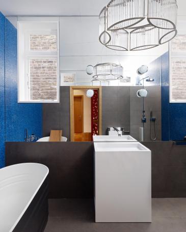 Bathrooms London with blue glass mosaics and sink in front of the mirror