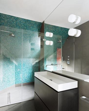 Bäder London mit grünen Glasmosaiken in der Dusche und freistehender Waschtisch vor Spiegel
