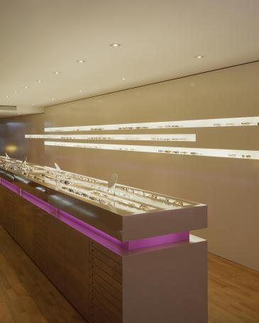 Urech Optik optician store eyewear display cabinets in the middle of the room and display wall at the back 
